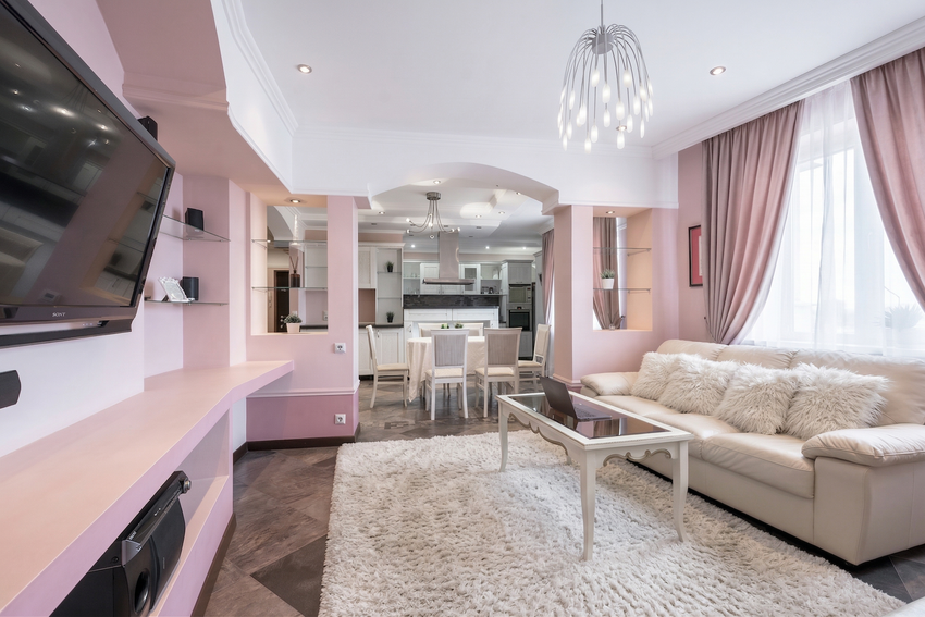 Гостиная: уютный диван, который раскладывается в дополнительное спальное место. Напротив — большой 65-дюймовый телевизор, подключенный к умной колонке с Алисой.