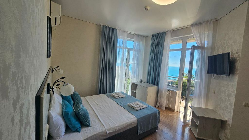 Четырёхместный номер делюкс с витражным окном и видом на море