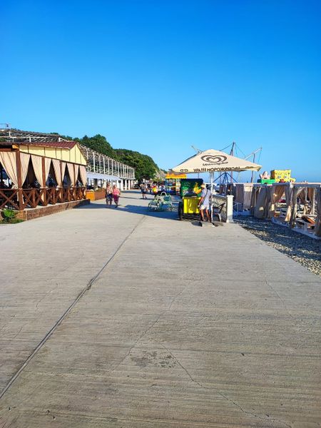 Пляж: кафе слева ,шатры справа.