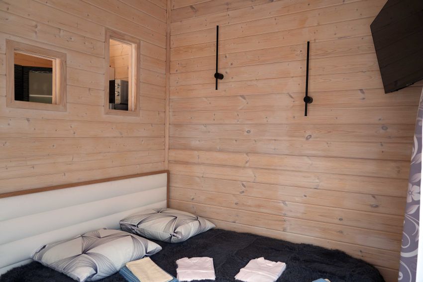 Это двухкомнатный домик с тремя основными спальными местами, кровати трансформеры