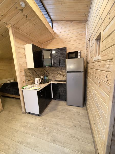 Кухня в двухкомнатном домике, имеется плита, чайник, холодильник и вся необходимая посуда для приготовления и приема пищи