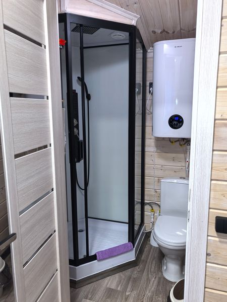 Санузел в домике оборудован душевой кабиной, есть фен, средства для купания, зубные щетки, тапочни, халаты