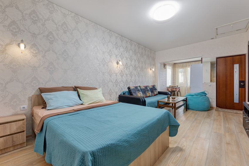 Вид на кровать, раскладной диван и проход на кухню.