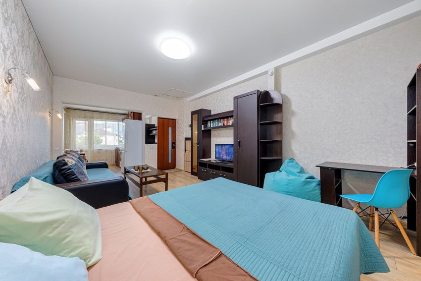 Вид на мебель, место для работы, кровать, раскладной диван и проход на кухню.