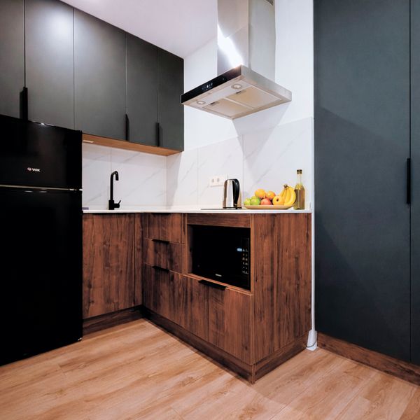 Современная полностью оборудованная кухня с плитой, вытяжкой, микроволновкой и холодильником с морозильной камерой. В наличии полный набор посуды и кухонных принадлежностей — удобно как для быстрого завтрака, так и для полноценного семейного ужина.