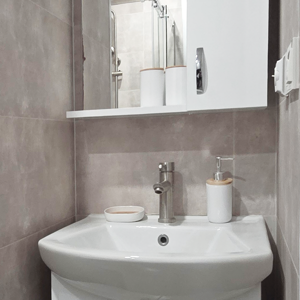 Современный санузел с душевой кабиной, раковиной с зеркалом и удобными шкафчиками для хранения. В распоряжении гостей стиральная машина и фен. Чистое, светлое и функциональное пространство для комфортного проживания.